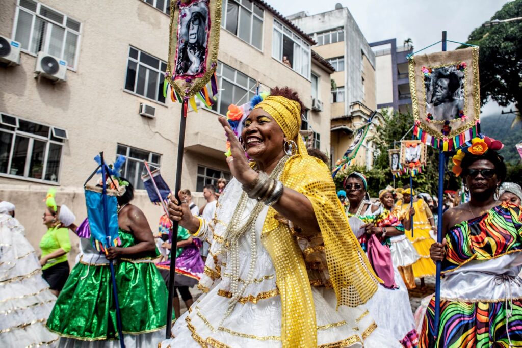 Mulheres fazendo um desfile de rua como uma dica de onde passar o carnaval com diversão