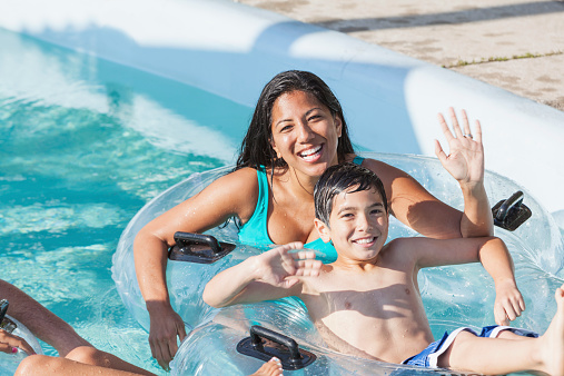 Mãe e filho que sabem o que fazer no dia das mães se divertindo em uma piscina em um dia de sol