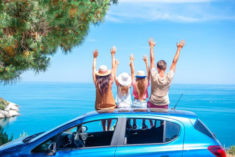 4 pessoas sentadas em cima de um carro azul e com os braços para cima depois de decidirem o que fazer no dia dos pais