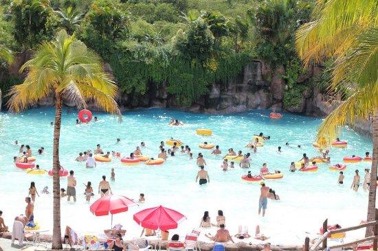 Piscina de ondas, um dos brinquedos do Thermas dos Laranjais, vista de longe com várias pessoas em boias
