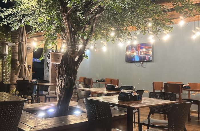 Mesa embaixo de uma árvore com luzes no Deck, um dos melhores restaurantes em Olímpia
