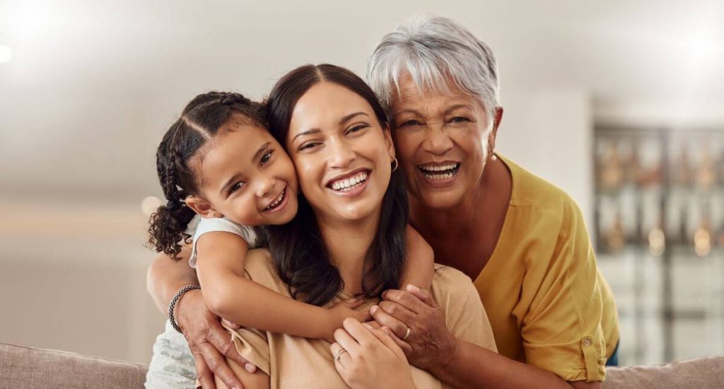 Avó, filha e neta abraçadas e felizes depois de decidirem juntas o que fazer no dia das mães