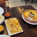 Pratos de comida sobre a mesa de quem já sabe onde comer em Olímpia e levou a família toda